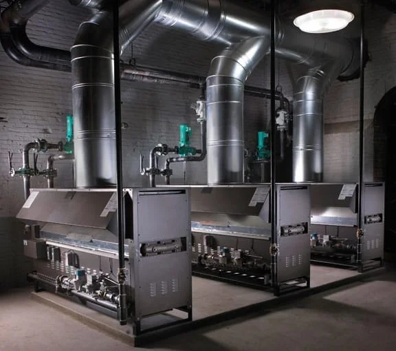 Triplex 1,000,000 BTU Boilers: The system heats a water source heat pump loop serving an industrial mill complex.